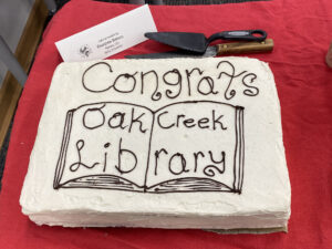 cake decorated with words "Congrats Oak Creek Library"