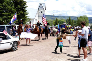 parade with horses, tractors, and flags